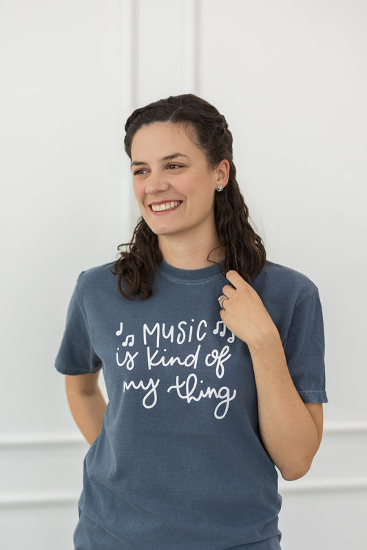 Woman wearing a blue t-shirt with text, standing against a white background