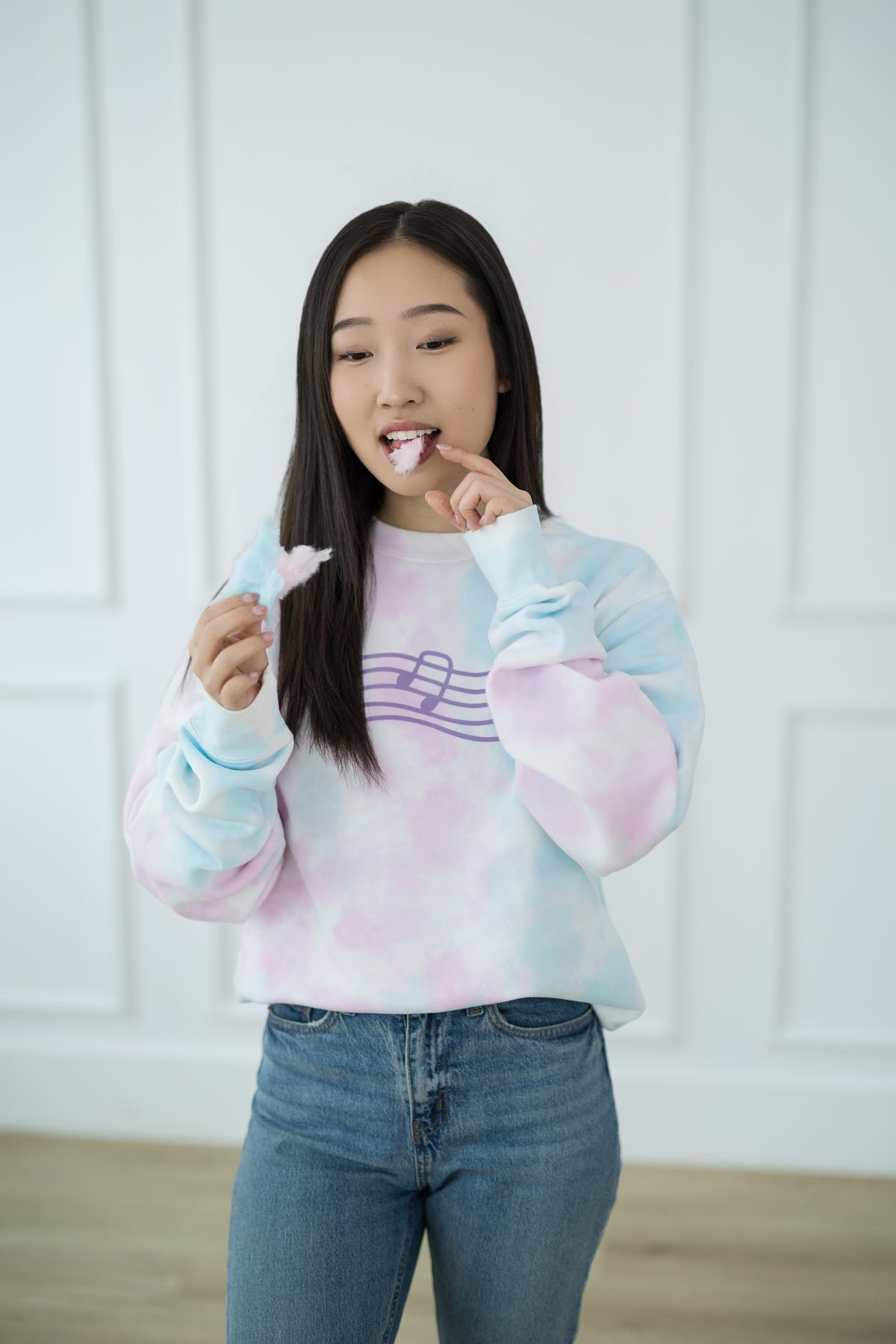 Person wearing a tie-dye sweater with a white background