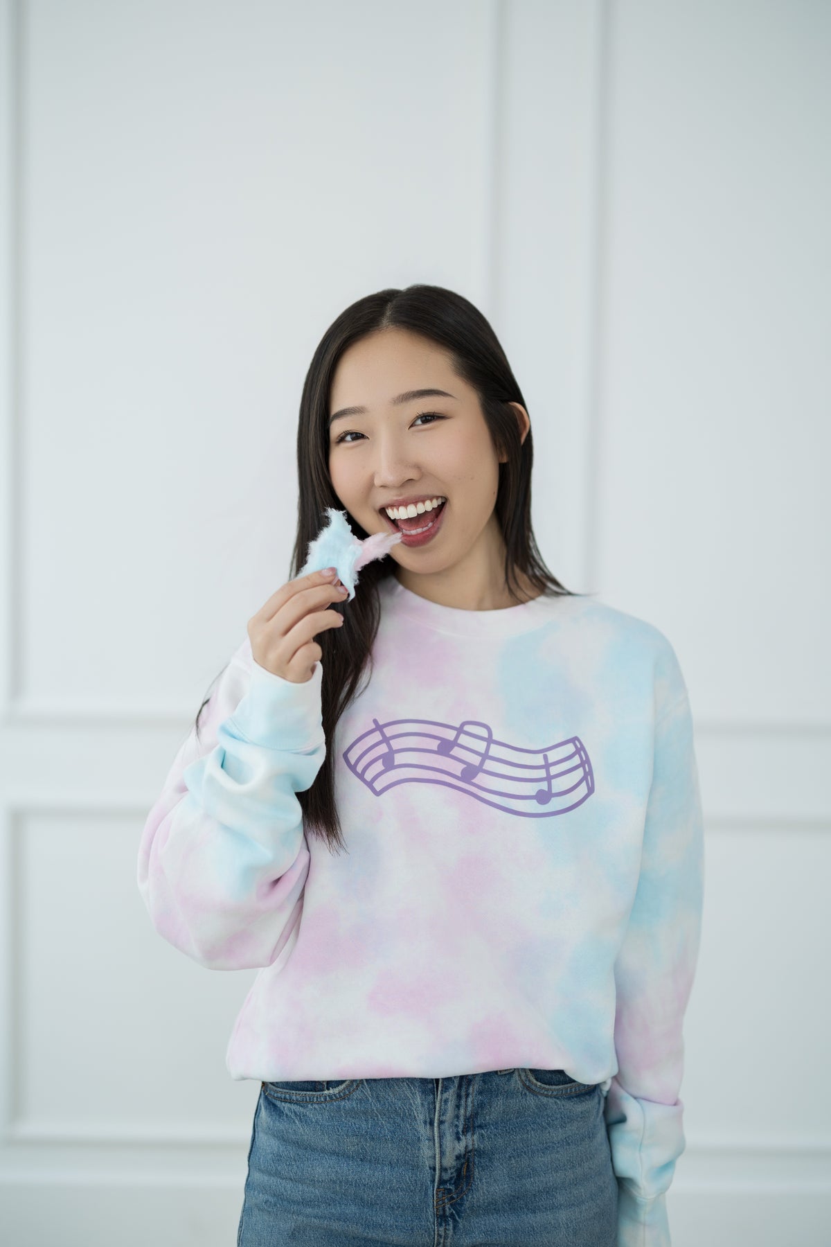 Person wearing a tie-dye sweater with a graphic design against a white background