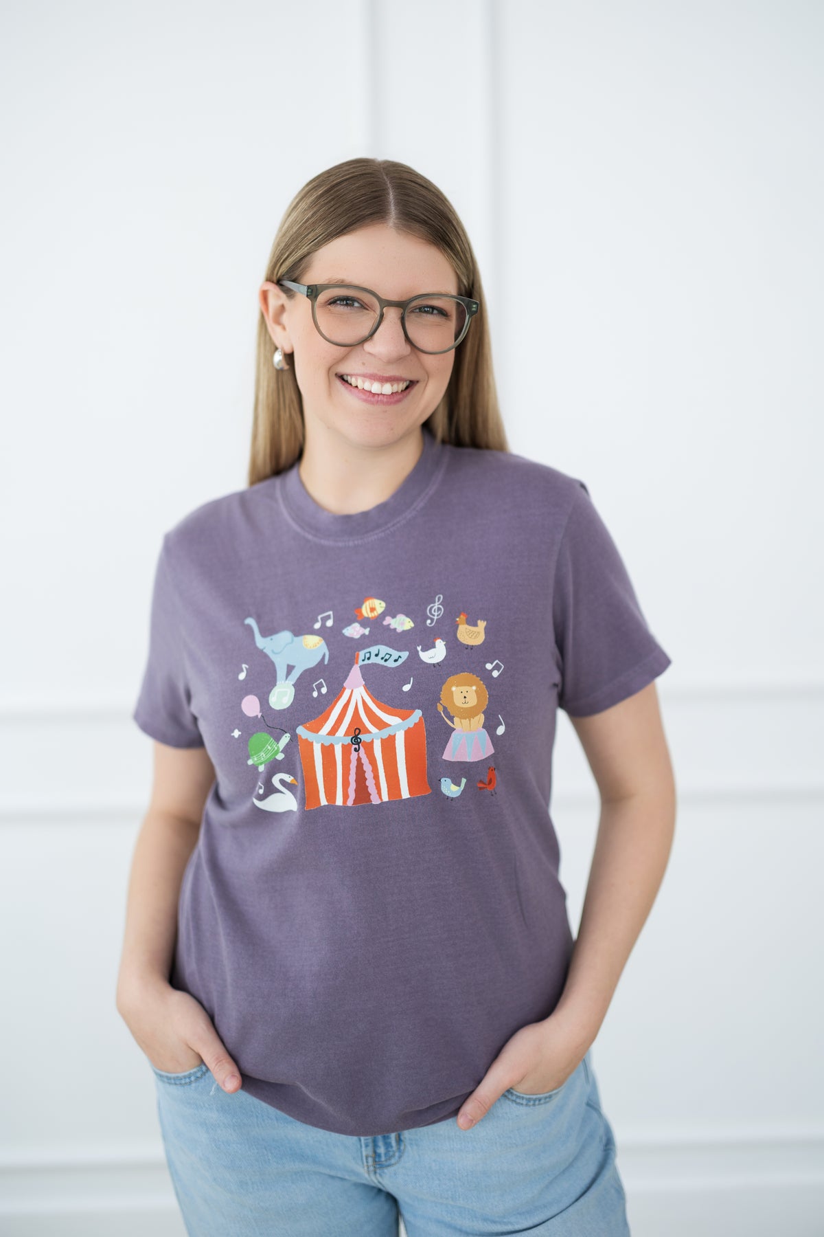 Woman wearing a purple t-shirt with a colorful graphic design against a white background