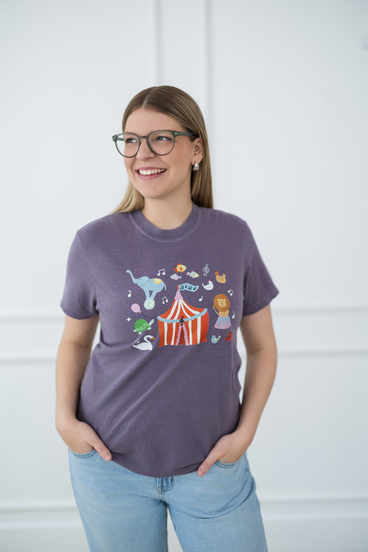 Woman wearing a purple t-shirt with a colorful graphic design against a white background