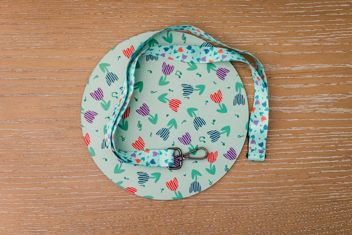 Music themed mousepad and lanyard with a tulip pattern on a wooden surface