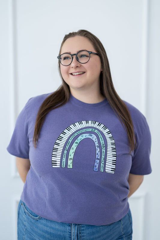 Person wearing a purple t-shirt with a rainbow design against a white background