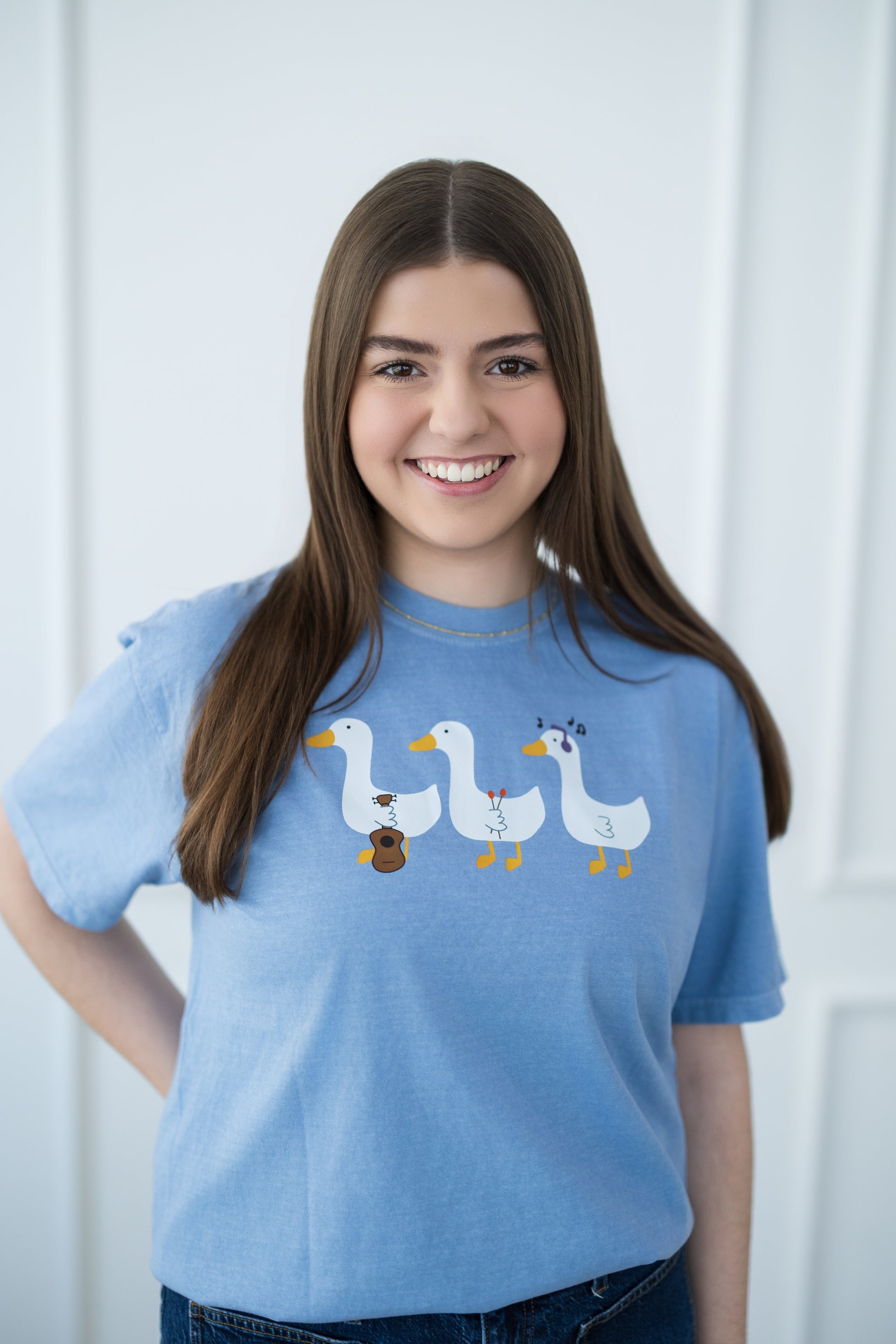 Person wearing a blue t-shirt with cartoon ducks on a white background