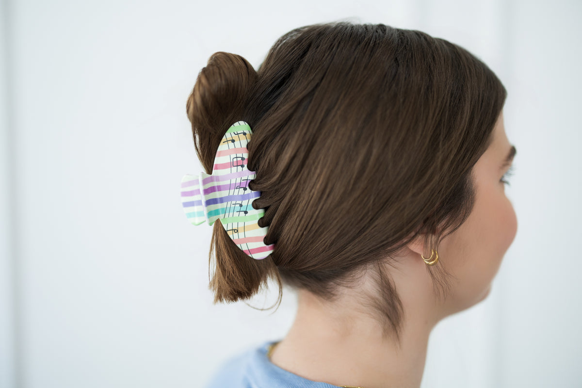 Woman with a colorful hair clip in her hair against a white background