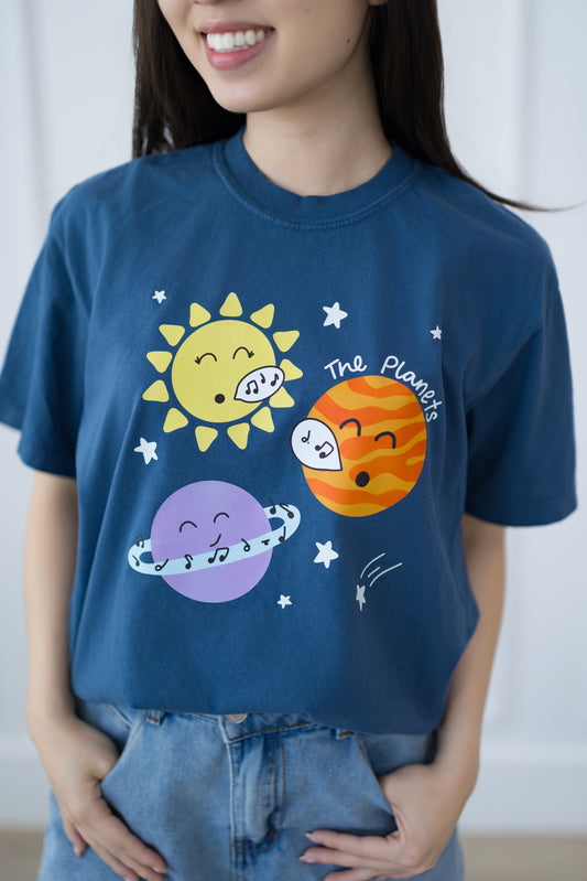 Person wearing a blue t-shirt with cartoon planet designs