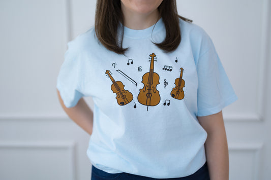 Person wearing a light blue t-shirt with musical instrument designs.