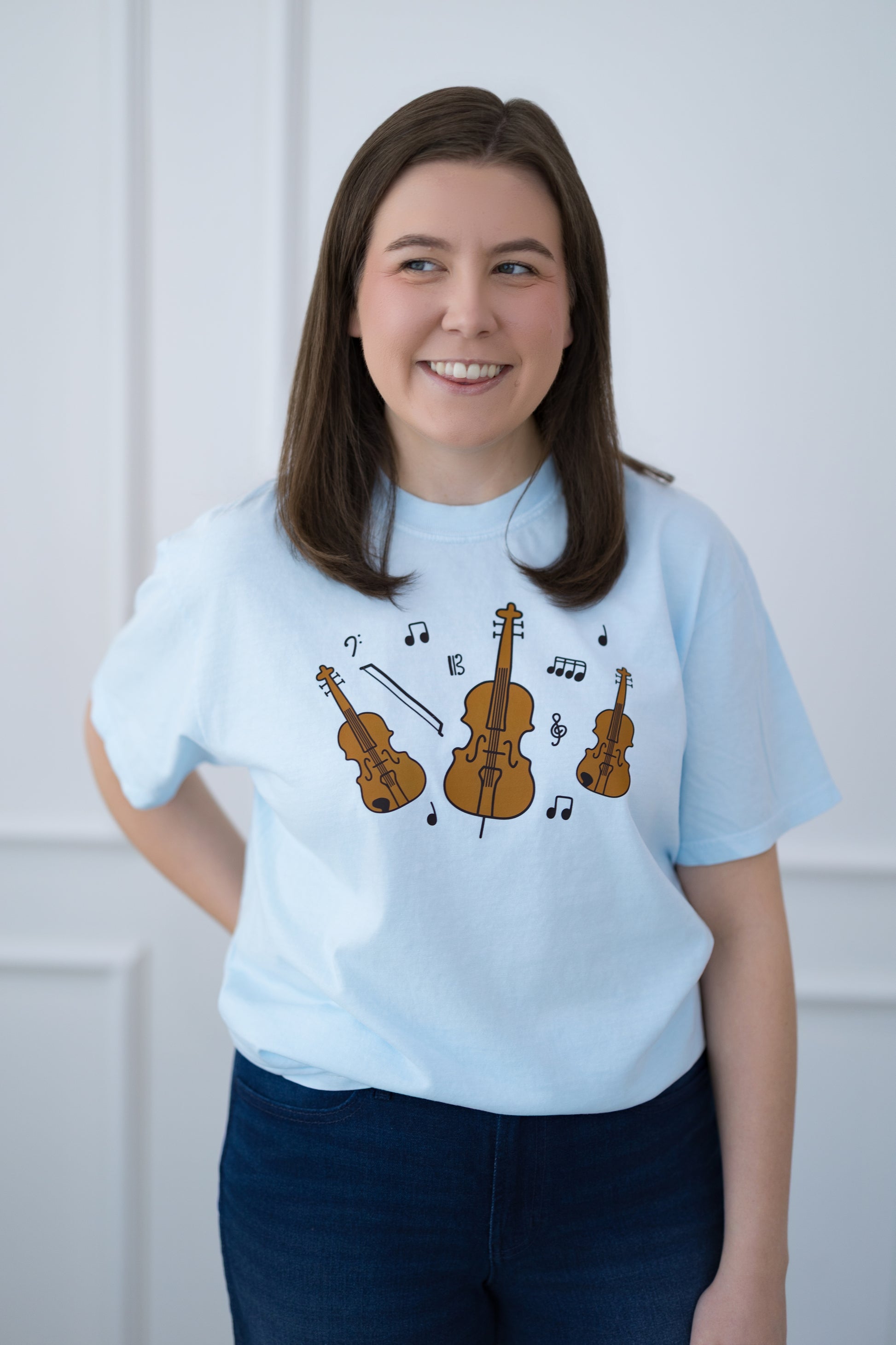 Person wearing a light blue t-shirt with musical instrument design