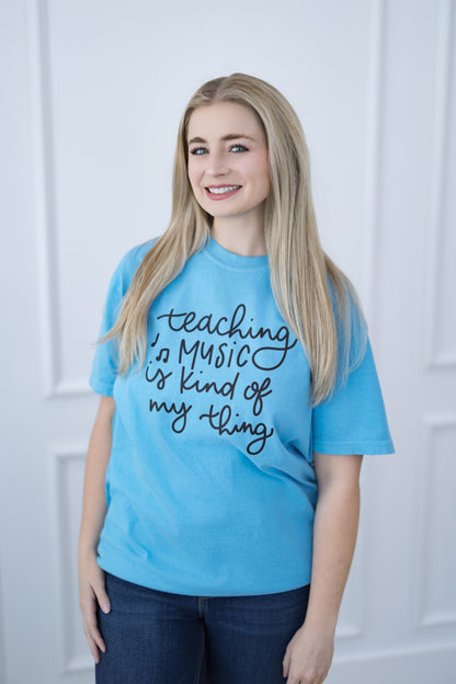 Woman wearing a blue t-shirt with text, standing against a white background