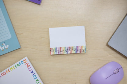 Colorful striped sticky notes on a wooden desk with a mouse and books.
